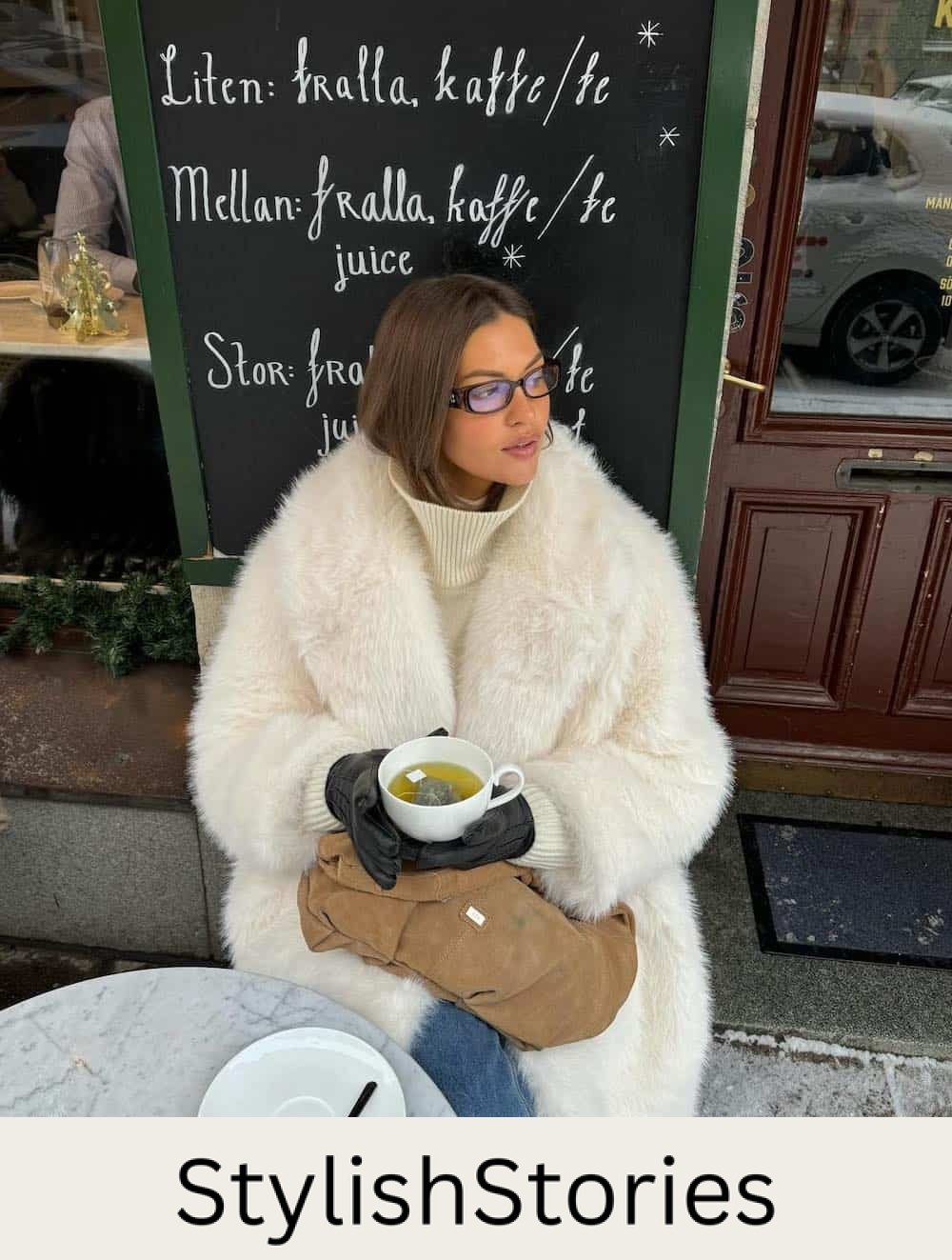 Woman wearing jeans, a cream turtleneck sweater and a long faux fur coat.