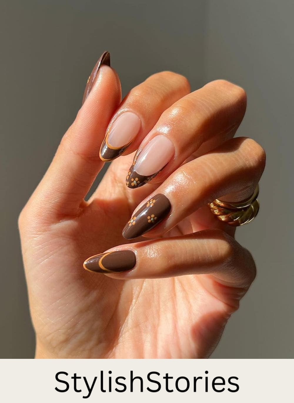 long almond nails with brown nails polish, orange accents, and floral art