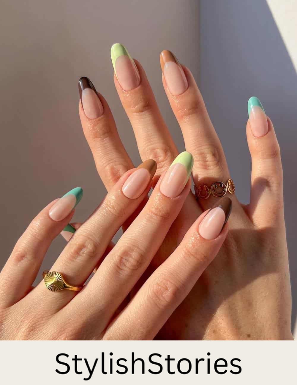 nude almond nails with light blue, light green, brown, and camel tips