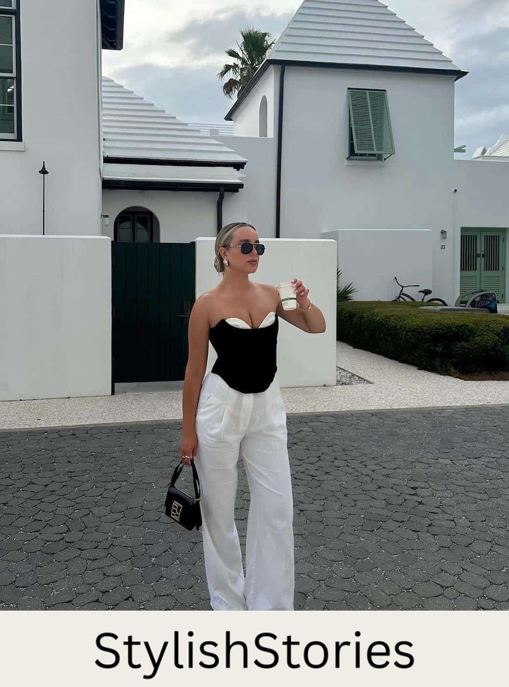 Woman wearing white linen pants with a black and white corset top.