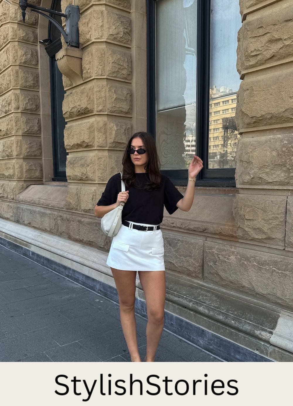 Woman wearing a white shirt with a black t-shirt and black sandals.