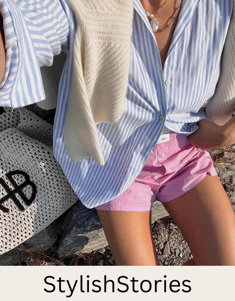 Christal wearing pink boxer shorts with an oversized blue and white striped button down.