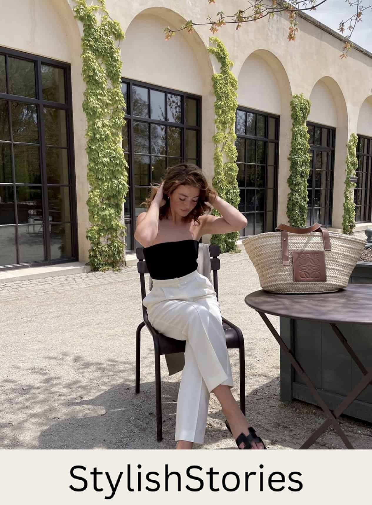 woman wearing a black strapless top with white trousers and black sandals at a winery