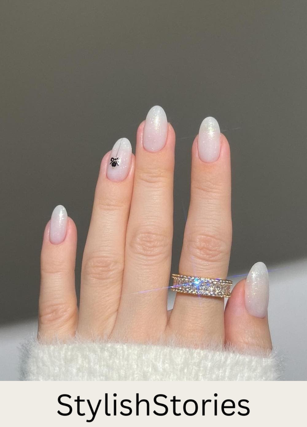 short glittery white round nails with a small ornament accent