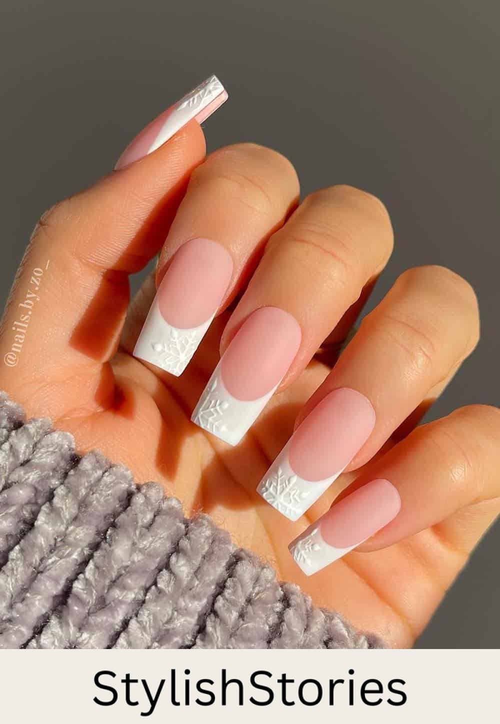 long square nude pink nails with white tips and snowflake details