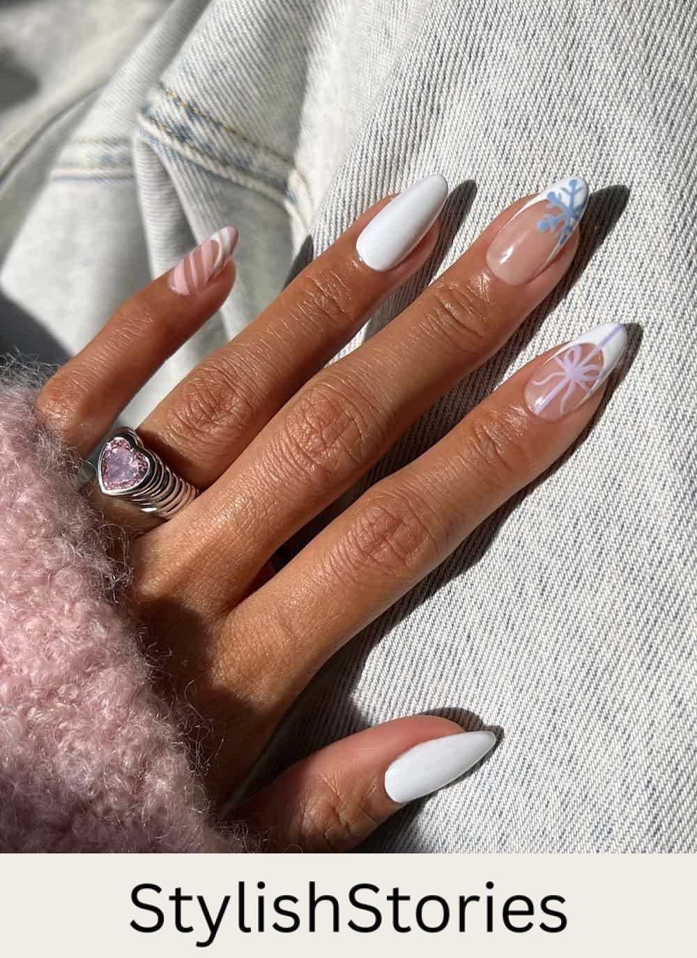 long almond nails with white polish, french tip accents, and colorful holiday nail art