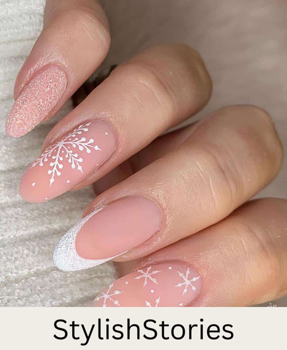 long nude pink nails with white glitter french tips, accent nails, and snowflakes
