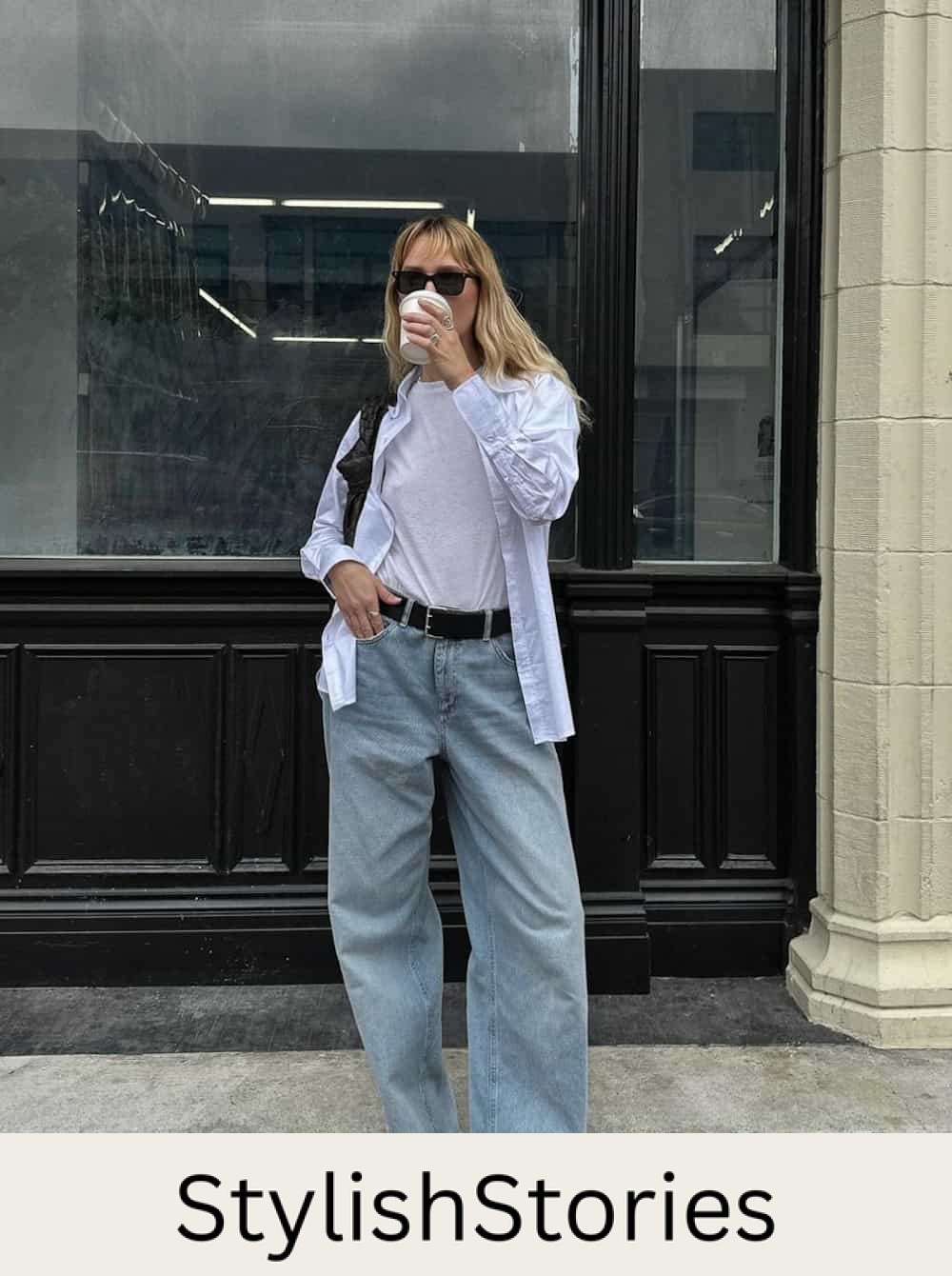 Woman wearing light wash wide leg jeans with a t-shirt and a button down.