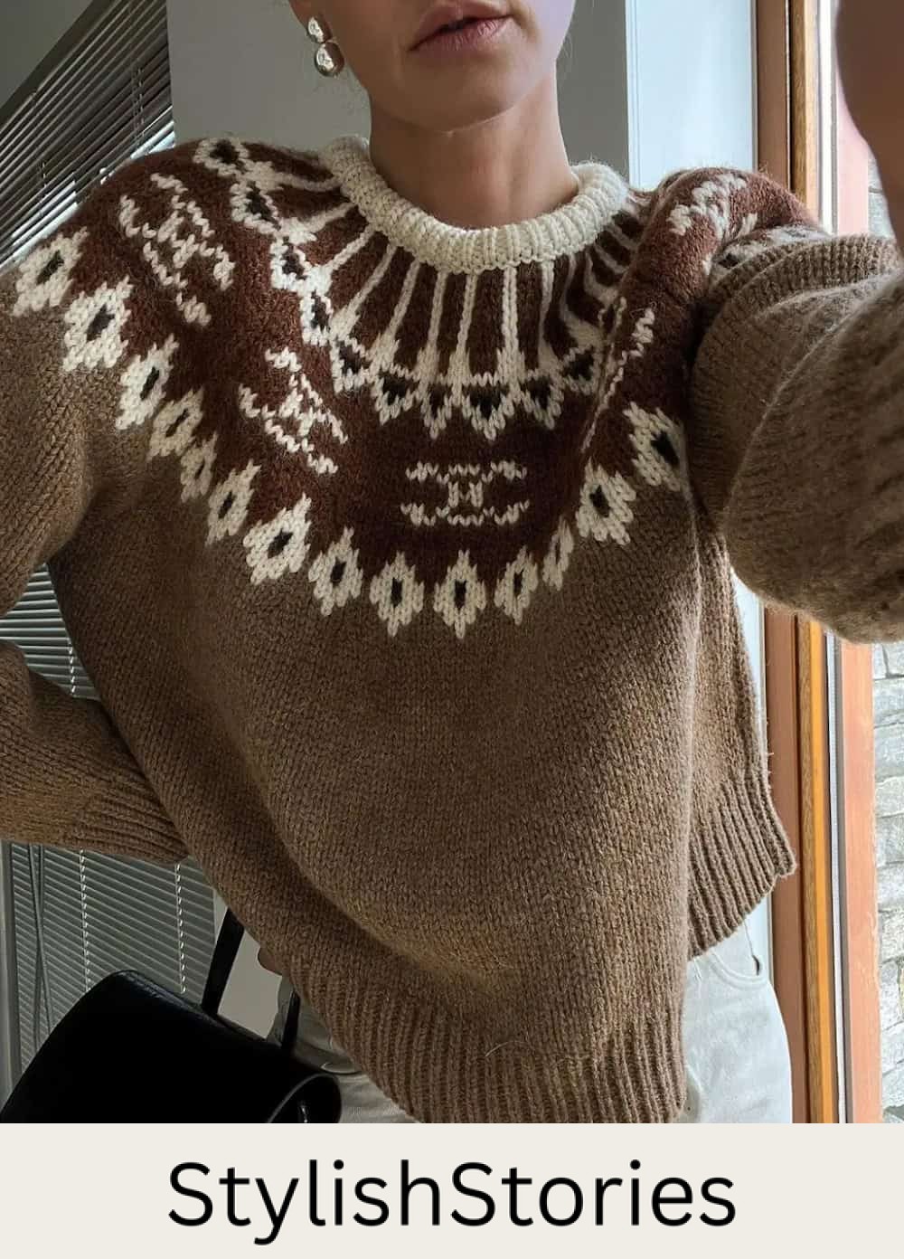 Woman wearing white jeans and a ski sweater.