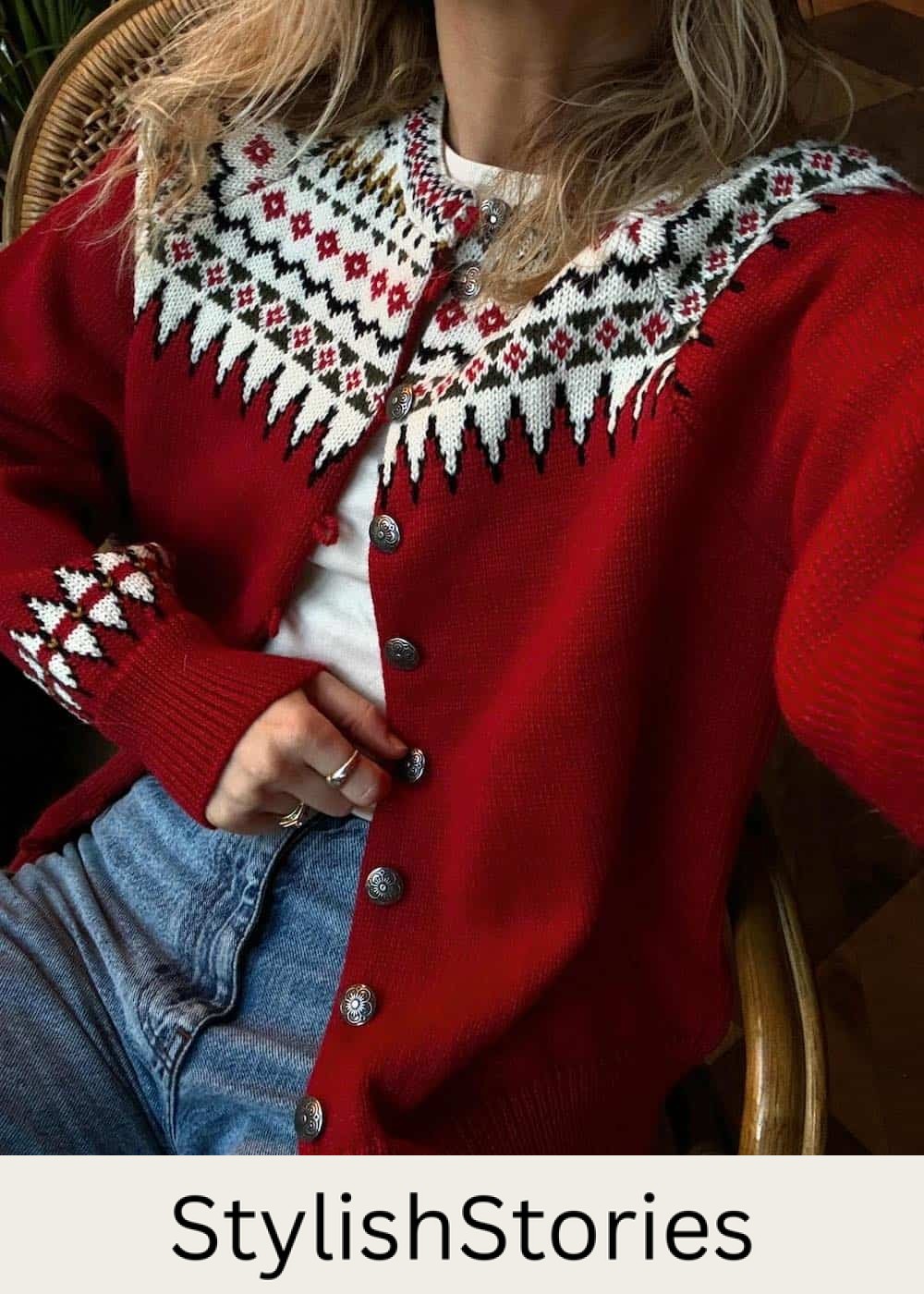 Woman wearing a red Christmas cardigan with a white t-shirt and jeans.