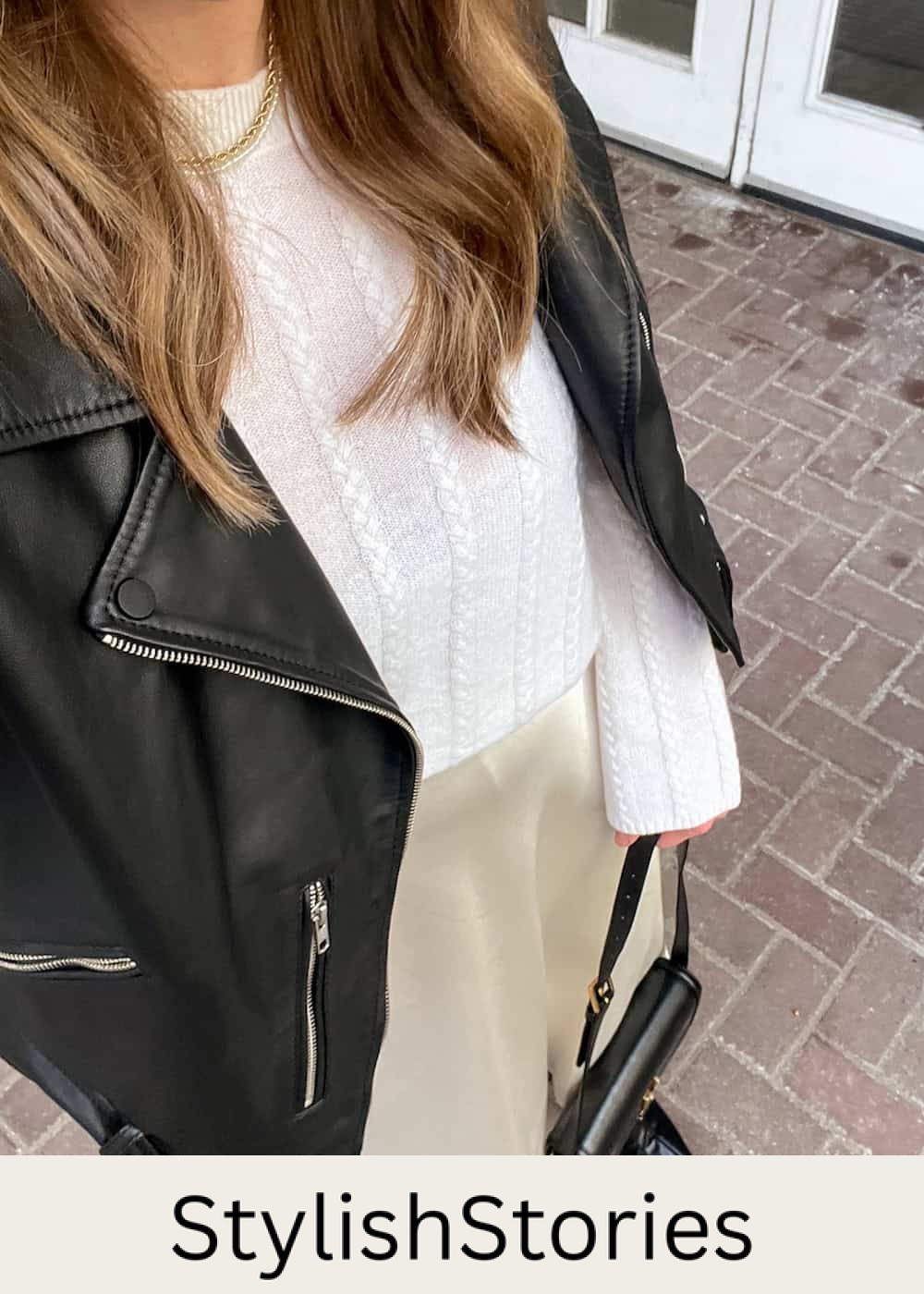 Christal wearing a cream satin slip skirt with a white cable knit sweater and a black leather jacket.