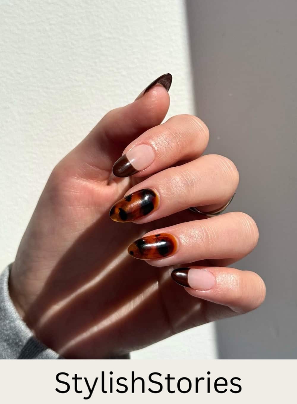 long nude nails with brown french tips and tortoise shell accent nails
